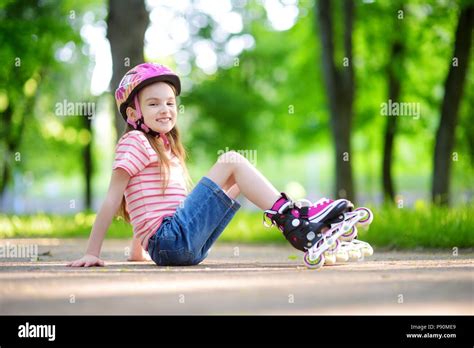 Pretty Little Girl Learning To Roller Skate Outdoors On Beautiful