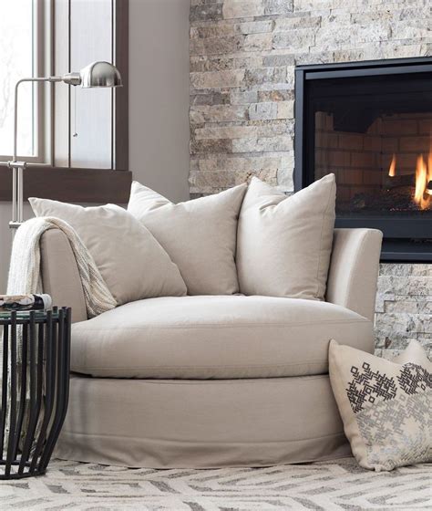 Cozy Neutral Corner By The Fireplace Swivel Slipcovered Chair