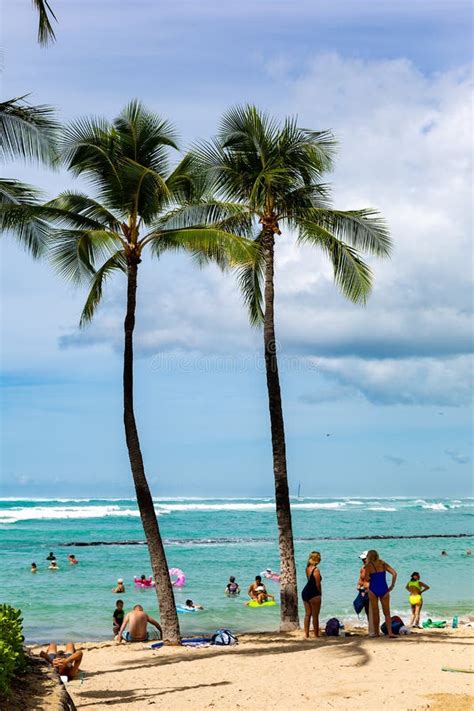 The Iconic Waikiki Beach During The Day With A Crowd Of People A