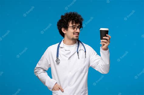 Premium Photo Doctors Day Curly Brunette Cute Guy In Lab Coat With Glasses Holding A Coffee Cup