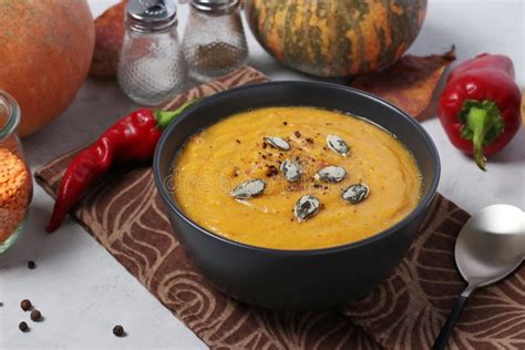 Vegetarian Autumn Creamy Pumpkin Soup With Red Lentils On Dark Plate