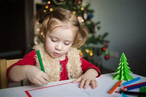 Lenfant écrit Une Lettre Au Père Noël Une Petite Fille Dessine Avec