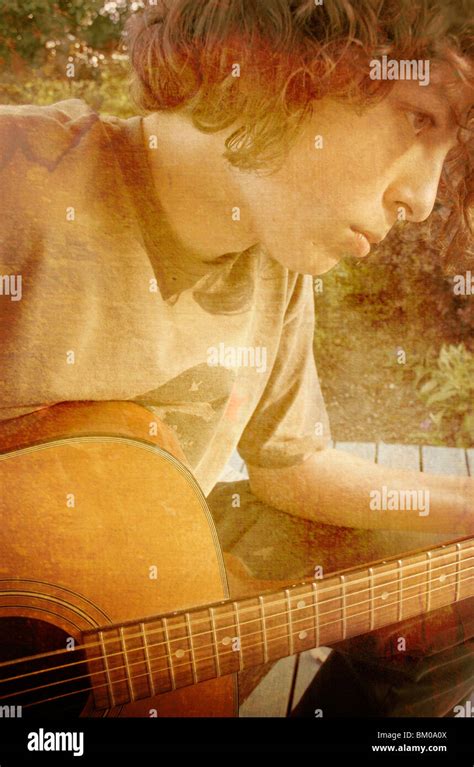 A Male Teenager Playing The Acoustic Guitar Outdoors Stock Photo Alamy