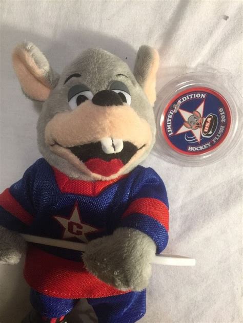 A Stuffed Animal Mouse With A Red And Blue Shirt On Its Chest Holding