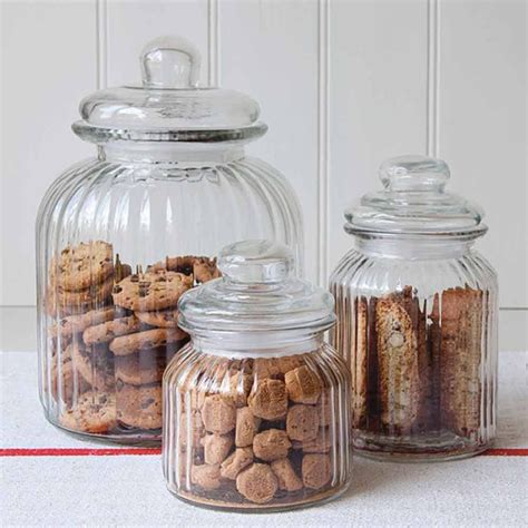 Three Glass Jars Filled With Cookies On Top Of A Table