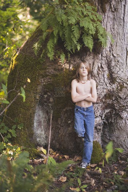 Portrait Of Shirtless Boy With Arms Crossed Standing By Tree In Forest