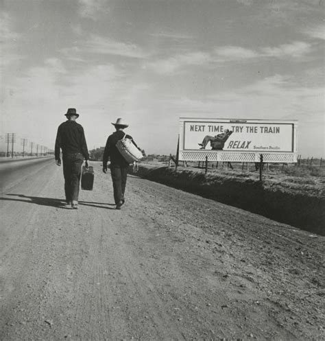 Black And White Photograph Of Two Men Walking Down The Road