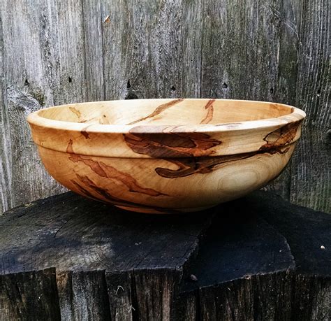 A Wooden Bowl Sitting On Top Of A Piece Of Wood
