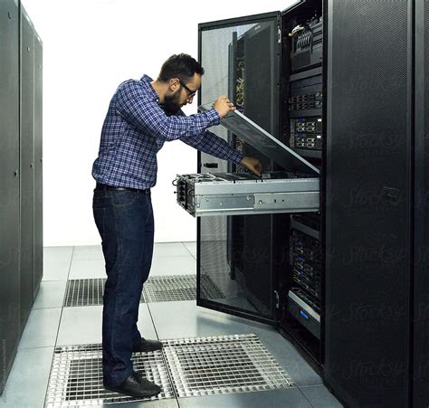 Technician Performing Maintenance Tasks In A Server Room Rack By