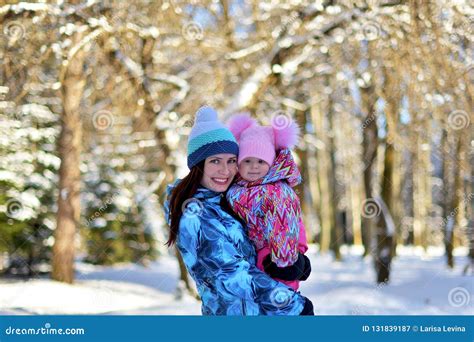 Mother With A Little Daughter On A Walk In The Woods On A Snowy Winter