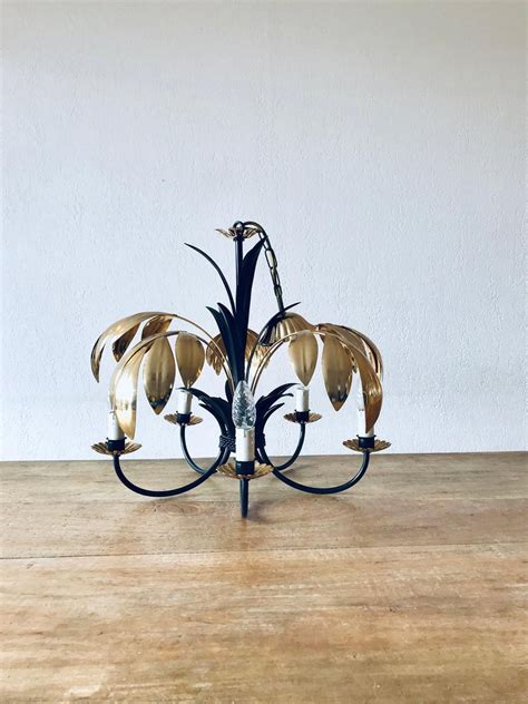 Ribbon arms appear as delicate branches sprouting from a. 70s chandelier in black and gold metal in 2020 | Metal ...