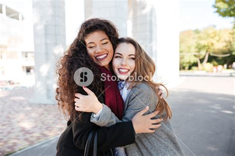 Photo Of Happy Meeting Of Two Friends Hugging With Street On Background