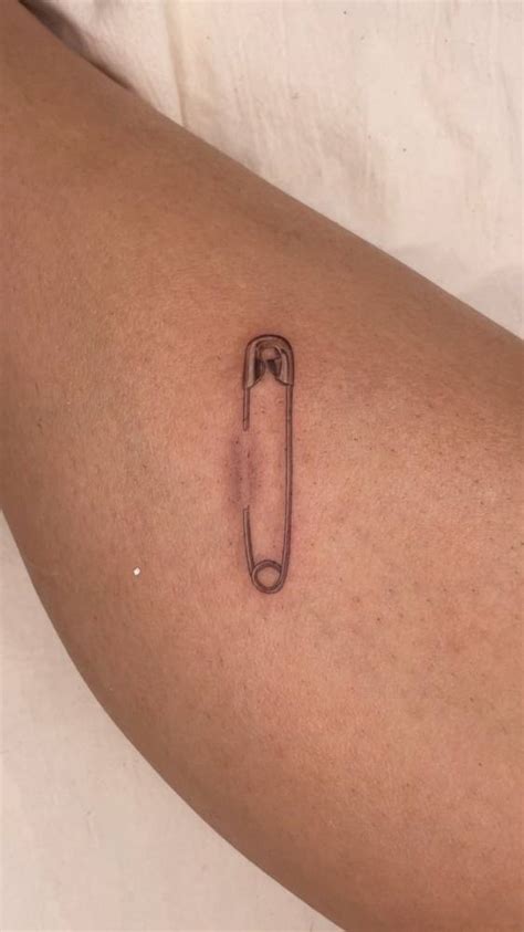 micro realistic safety pin tattoo on the shin