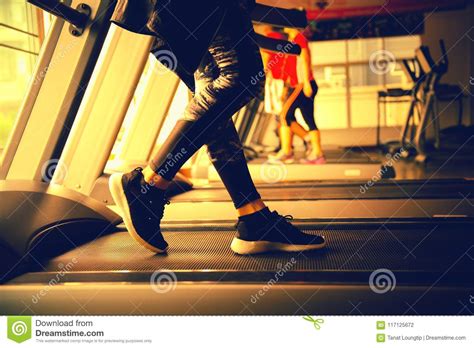 Closeup Of Woman Running In Machine Treadmill At Fitness Gym Stock