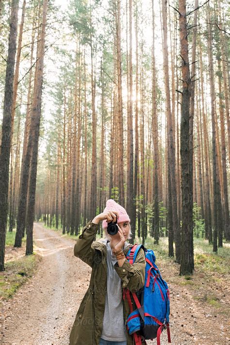 girl in pink hat taking photo with camera in forest by stocksy contributor danil nevsky
