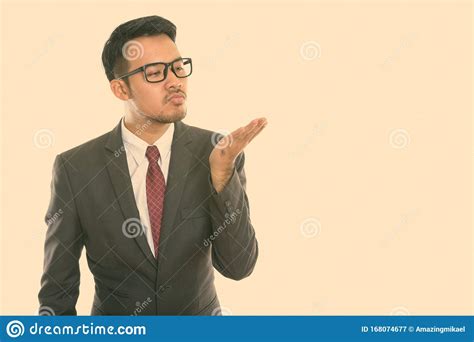 Studio Shot Of Young Asian Businessman Giving Flying Kiss Stock Image