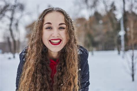 A Young Happy Woman Is Having Fun In A Winter Park Throwing Snow It