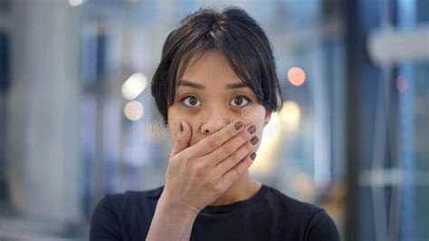 Portrait Of Attractive Scared Asian Female With Her Hand Nearby Her