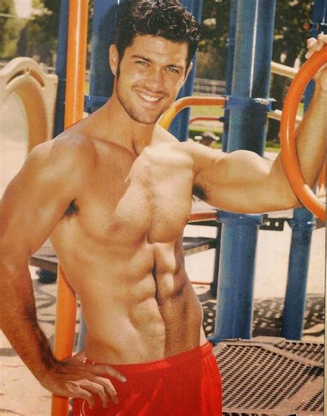 A Shirtless Man Posing In Front Of A Playground