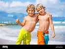 Two young boys having fun on tropical beach, happy best friends playing ...