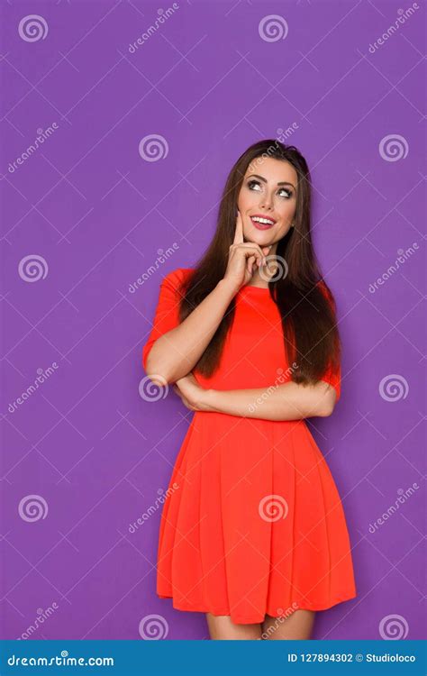 Smiling Beautiful Woman In Red Mini Dress Is Thinking And Looking Up