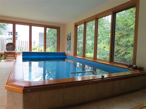 An Indoor Swimming Pool In The Middle Of A Room With Large Windows And