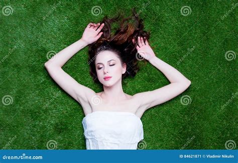Portrait Of A Young Redhead Woman Lying Down On Green Spring Grass