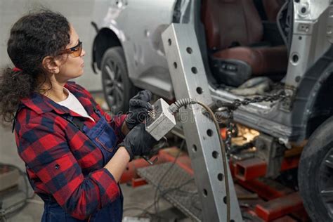 Female Auto Mechanic Using Car Diagnostic Equipment In Garage Stock