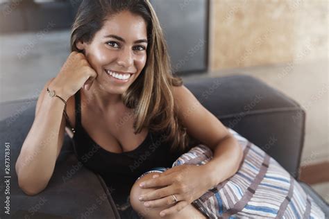 Joyful Lovely Feminine Young Tanned Hispanic Woman Lying Sofa Hugging Pillow Gently Lean Head