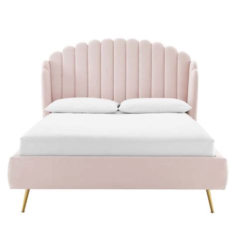 An Upholstered Bed With Pink Velvet Headboard And White Pillows On The
