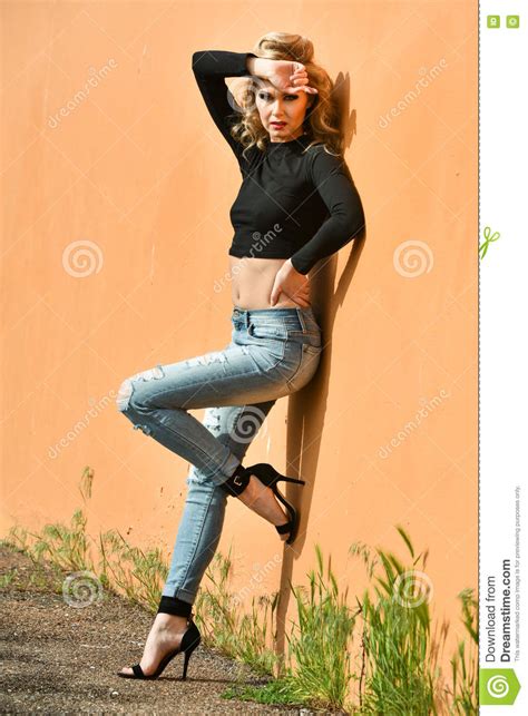 Glamour Fashion Model With Perfect Slim Body Posing Outside At The Wall