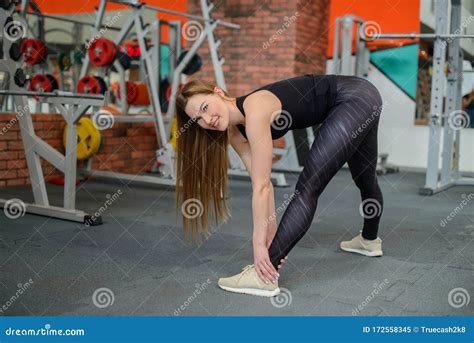 portrait of fitness woman stretching at gym before workout female stretch inner thigh sports