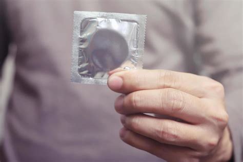 condoms ready to use in female hand give condom safe sex concept on the bed prevent infection
