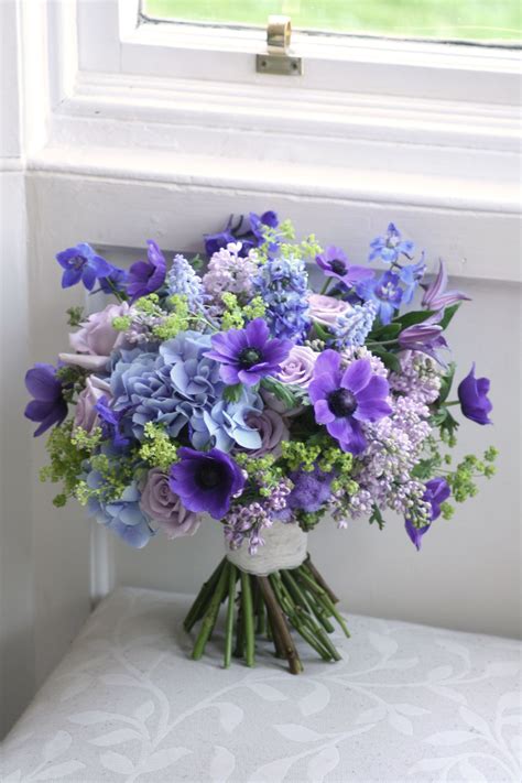 wedding bouquet in blue purple and green with anemone roses delphinium muscari hydrang