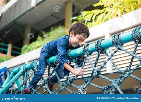 Little Boy Climbing On The Rope At Playground Outdoor Stock Image