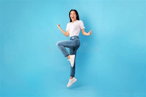Happy Woman Jumping And Looking At Camera At Studio Stock Photo Image
