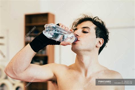 Man Drinking Water From Bottle In Gym — Focus On Foreground Refresh