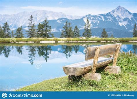 Mountain Lake Landscape View With Bench In Foreground Stock Photo