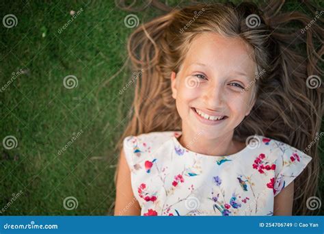 Retrato De Una Niña Pequeña Y Mona Sonriente En El Césped Verde Imagen