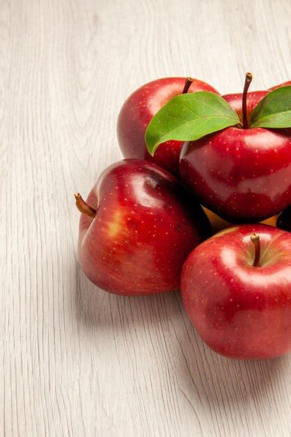 Vista frontal de maçãs vermelhas frescas frutas maduras e maduras na mesa branca frutas