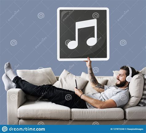 Male On A Couch Holding A Musical Note Icon Stock Photo Image Of