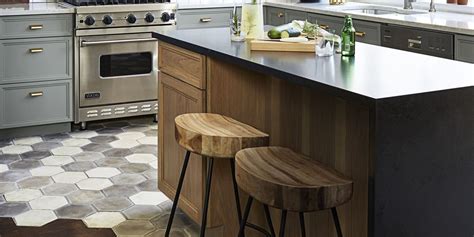 Two Stools Are In Front Of The Kitchen Island With An Oven And Countertop