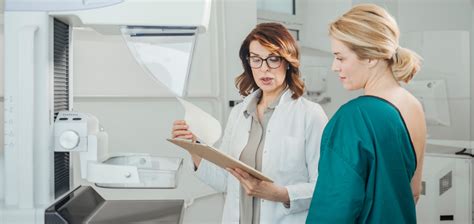 Woman Oncologist Talking With Her Patient On Mammography Examination