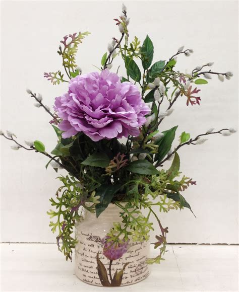A Vase Filled With Purple Flowers And Greenery