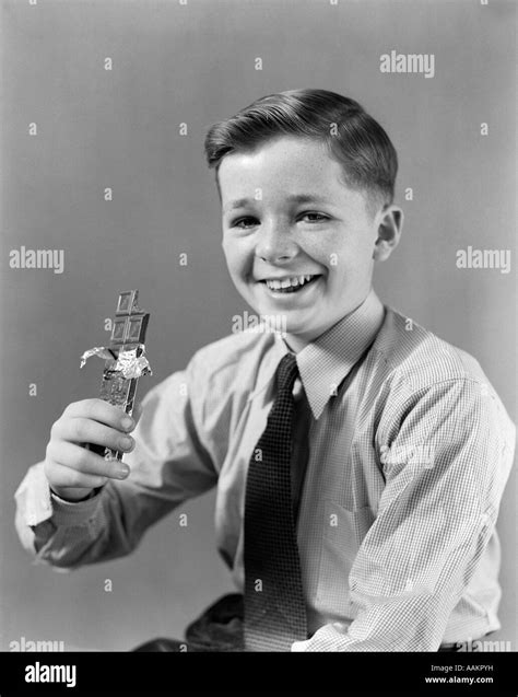 1940s Smiling Boy Holding Eating Candy Bar Chocolate Looking At Camera