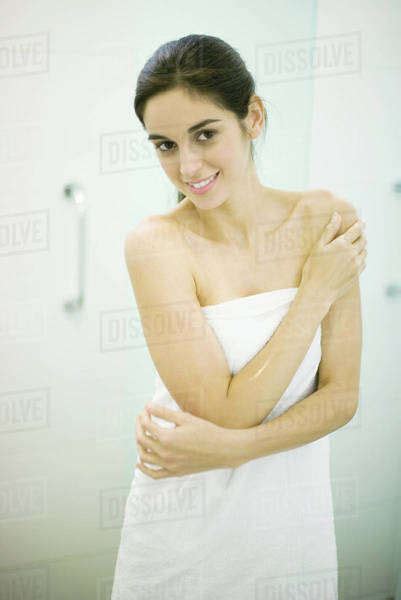 Woman Standing Wrapped In Towel Hand On Shoulder Looking At Camera Stock Photo Dissolve