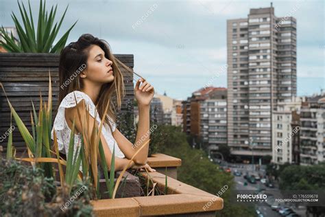 Sensual Woman Posing On Balcony With Buildings Facades On Background