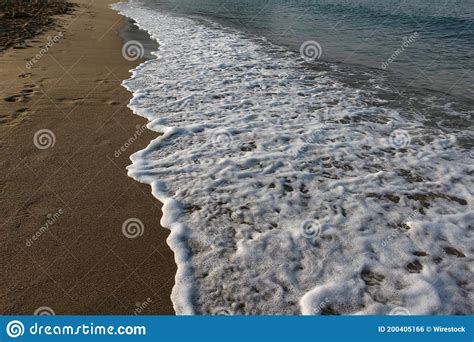 High Angle Shot Of A Sandy Beach With Foamy Waves Stock Photo Image