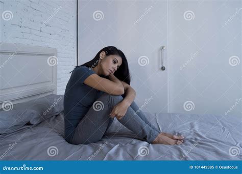 Beautiful Sad And Depressed Latin Woman Sitting On Bed At Home F Stock