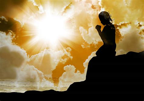 Silhouette Of Woman Kneeling In Prayer Stock Photos Pictures And Royalty